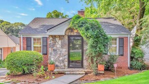 A two-story house with a stone facade, a black front door, and a number '482' on the door. - EnDeering Retreat Stay (Atlanta)