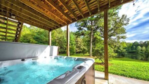 Un bain à remous sous une pergola en bois, avec vue sur un paysage verdoyant.