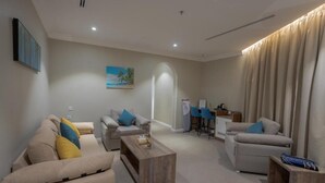 A modern living room with a sofa set, a coffee table, and a dining area with a table and chairs.