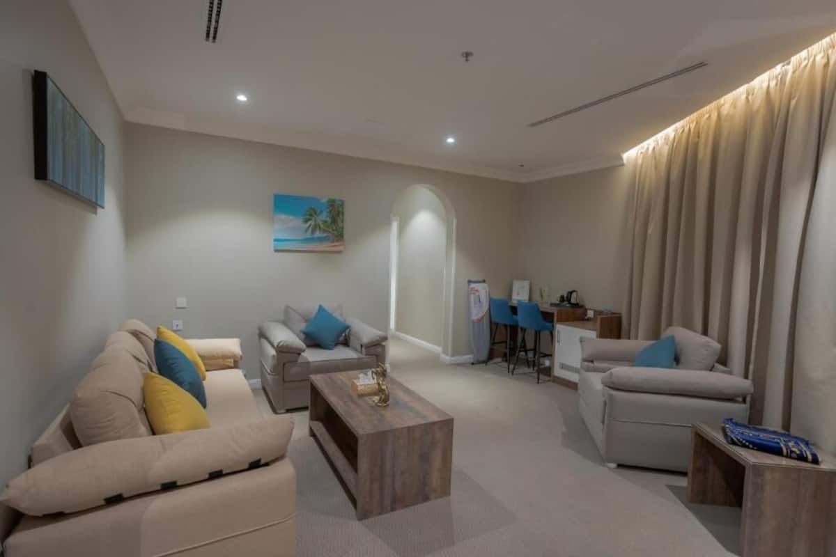 A modern living room with a sofa set, a coffee table, and a dining area with a table and chairs.