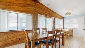 Un espace repas avec des murs en bois, une table en bois et des chaises.