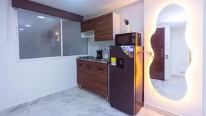 Eine moderne Küche mit integriertem Mikrowellenherd, Kühlschrank und einem Fenster.