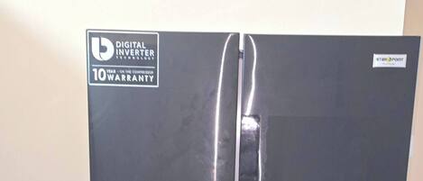 A black refrigerator with a digital inverter technology label, a 10-year warranty, and a water dispenser.
