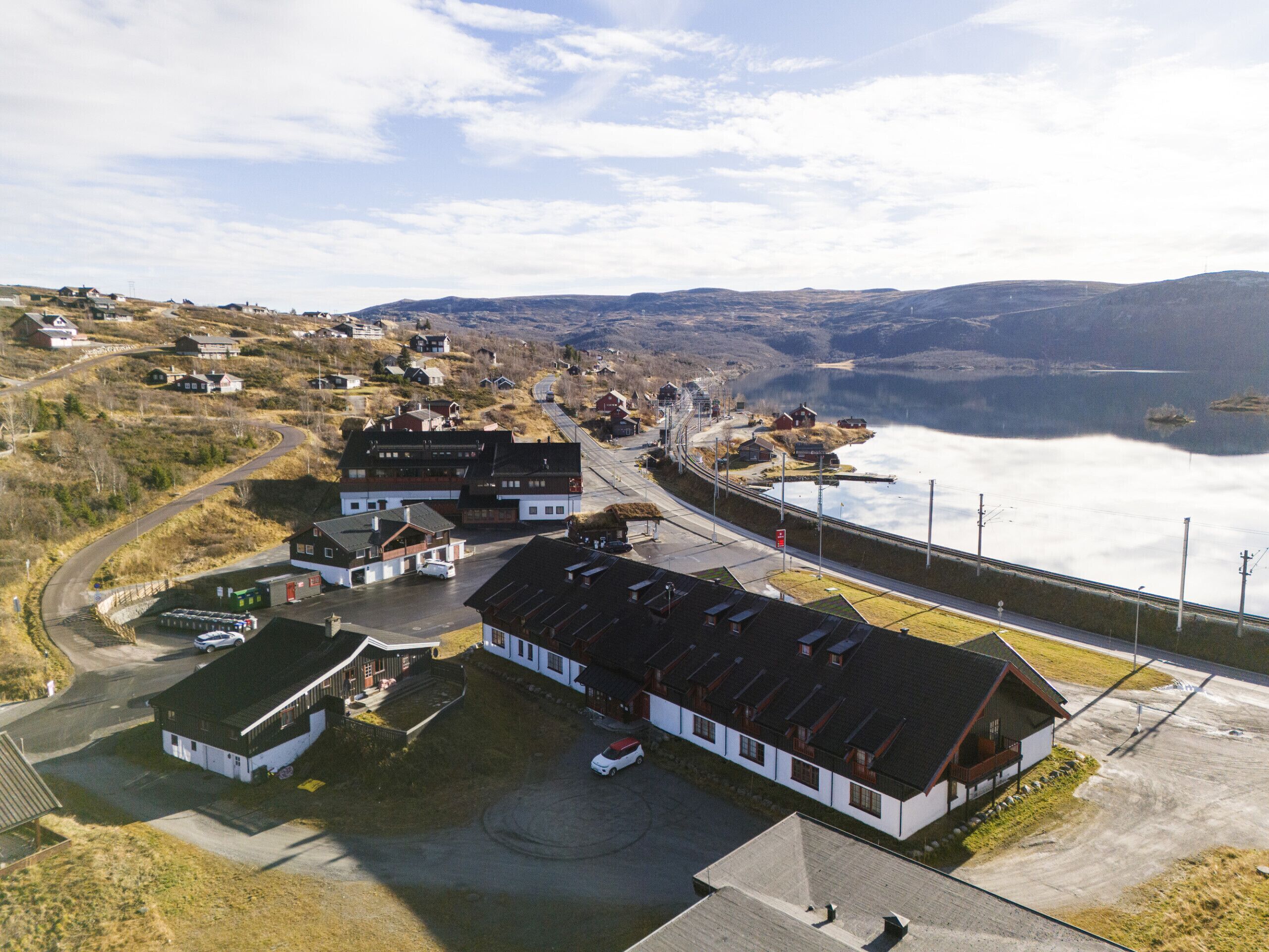 En kystby med en blanding af boliger og erhvervsbygninger, en vej der fører til havet, og en bro der forbinder de to.