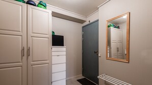 A hallway with a white wardrobe, a dark door, a radiator, and a mirror on the wall. - Alpine Apartment with Parking and Balcony (Hol)