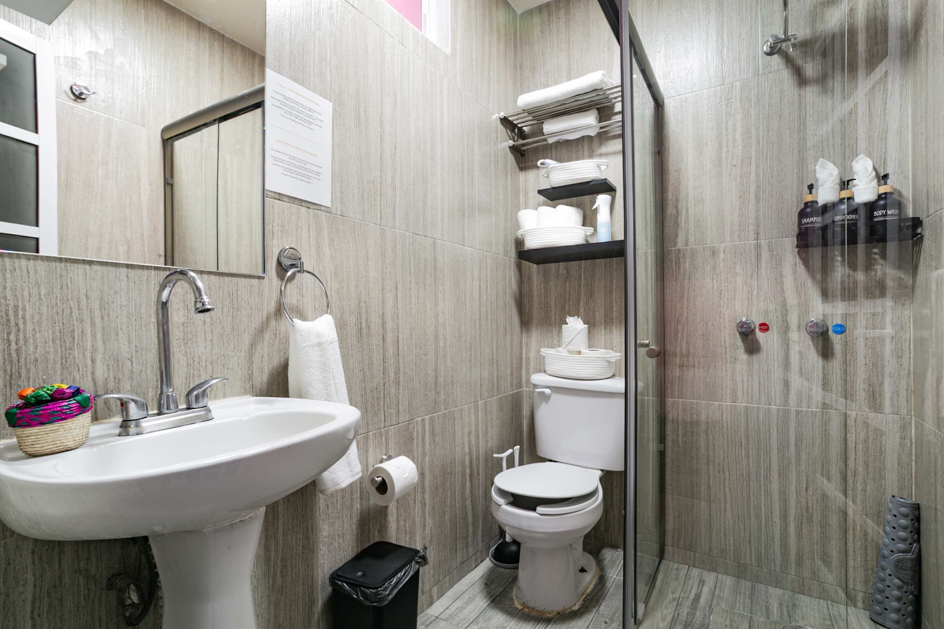 Uma casa de banho moderna com lavatório, sanita e chuveiro.