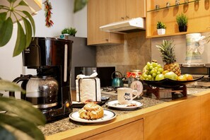 A kitchen with a coffee maker, a toaster, a fruit bowl, and a coffee cup on the counter. - Quiet-Street Condesa 3BR, 2 Kings, Balconies & AC (Mexico City)