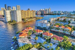 A coastal cityscape with high-rise buildings, a marina, and residential areas with red-roofed houses. - Luxury Waterfront W/ Heated Pool & Canal Views! (North Miami Beach)