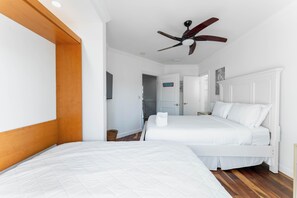 Ein Hotelzimmer mit einem großen Bett, einem Deckenventilator und einem Holzkopfschild.