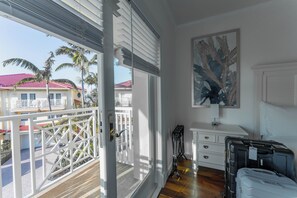 A room with a balcony, a painting, a desk, and a bed. - Luxury Waterfront W/ Heated Pool & Canal Views! (North Miami Beach)