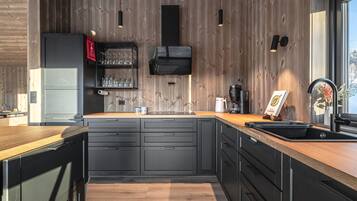 Une cuisine moderne avec des murs en bois, un four encastré et une grande fenêtre.