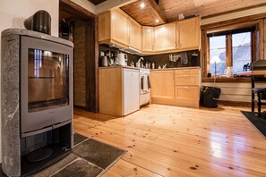 A kitchen with wooden cabinets, a stove, and a window.