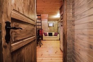 A wooden interior with a sofa and a window.