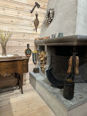 Un interior rústico con chimenea de piedra, muebles de madera y varios objetos decorativos.
