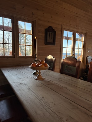 Un intérieur en bois avec une table, une bougie et une chaise.