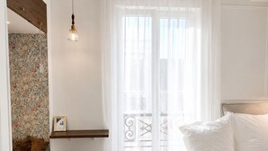A bedroom with a bed, a desk, a chair, a hanging light, and a window with a view of buildings. - Central Paris Apartment near Opéra & Galeries Lafayette (Paris)