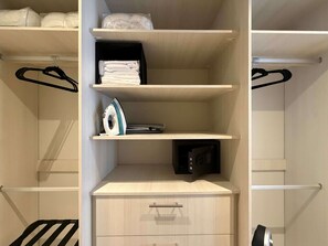 Ein Schrank mit Regalen, einer Kleiderstange und einem Safe.