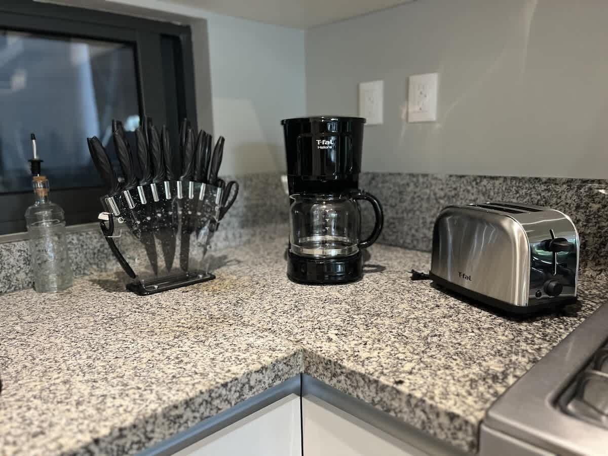 Eine Küchenarbeitsplatte mit Kaffeemaschine, Toaster und Messerhalter.