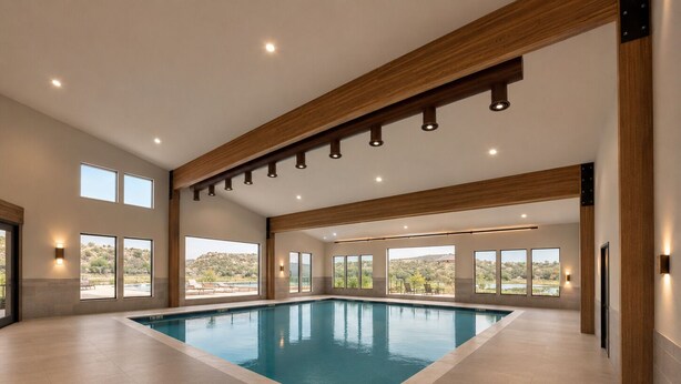Une grande piscine intérieure dotée de nombreuses fenêtres et offrant une vue sur un paysage naturel.