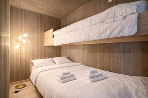 A bunk bed room with a wooden ceiling, a bedside lamp, and neatly folded towels on the bed. - Modern ski-in/ski-out apartment in Hemsedal (Hemsedal)