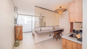Een moderne keuken met een ingebouwde kookplaat, een houten aanrecht en een grote spiegel boven de gootsteen.