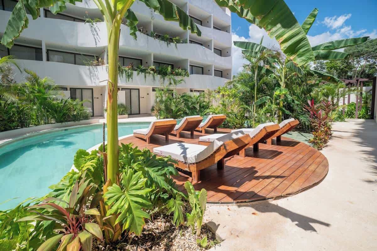 Un espace aménagé au bord de la piscine, avec des chaises longues et une terrasse en bois.