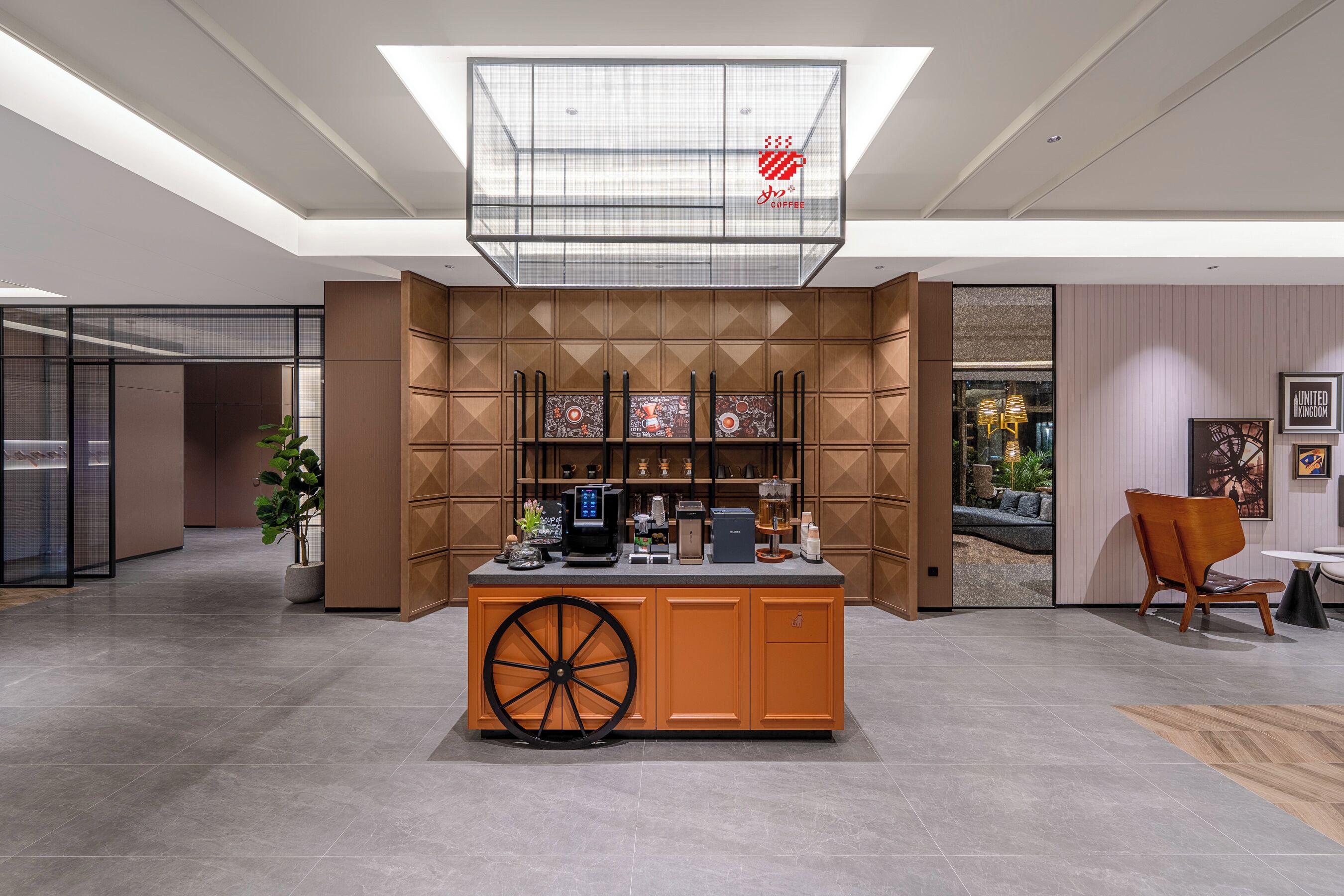 A modern bar area with a coffee machine, seating, and a view into a room with a sofa and plants.