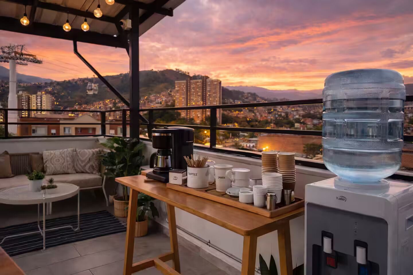 Terraza en la azotea con estación de café, zona de estar y dispensador de agua.