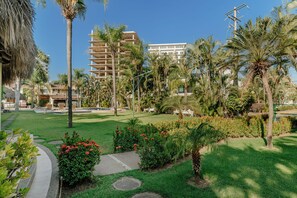 Ein Hotelinnenhof mit Palmen, einem Pool und einem Gebäude mit Balkonen.