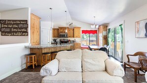 A modern kitchen with wooden cabinets, a central island, and bar stools.