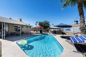A swimming pool with a hot tub, lounge chairs, and umbrellas. - Sunset Springs - 4BR Home w/ Private Pool, Hot Tub (Phoenix)