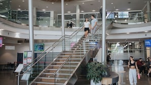 A multi-level indoor space with a central staircase, glass railings, and seating areas. - Hotel Burnaby (Burnaby)