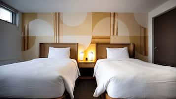 Une chambre d’hôtel avec deux lits simples, une table de chevet avec des lampes et une grande fenêtre.