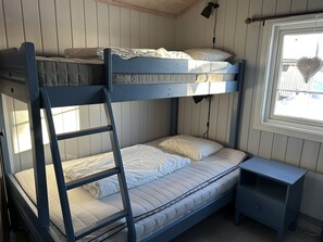 A bunk bed room with a ladder, a small bedside table, and a window with a heart-shaped decoration. - Mountain cabin in Lillehammer (Lillehammer)