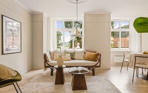 Ein gemütliches Wohnzimmer mit einer Couch, einem Couchtisch und einem Essbereich mit Stühlen.