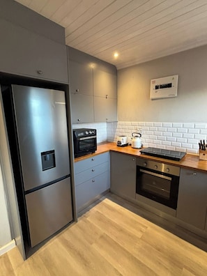 Een moderne keuken met roestvrijstalen apparatuur, een magnetron, een broodrooster en een inbouwoven.