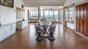 Un comedor amplio con techo alto, ventanas grandes y vistas a la ciudad.