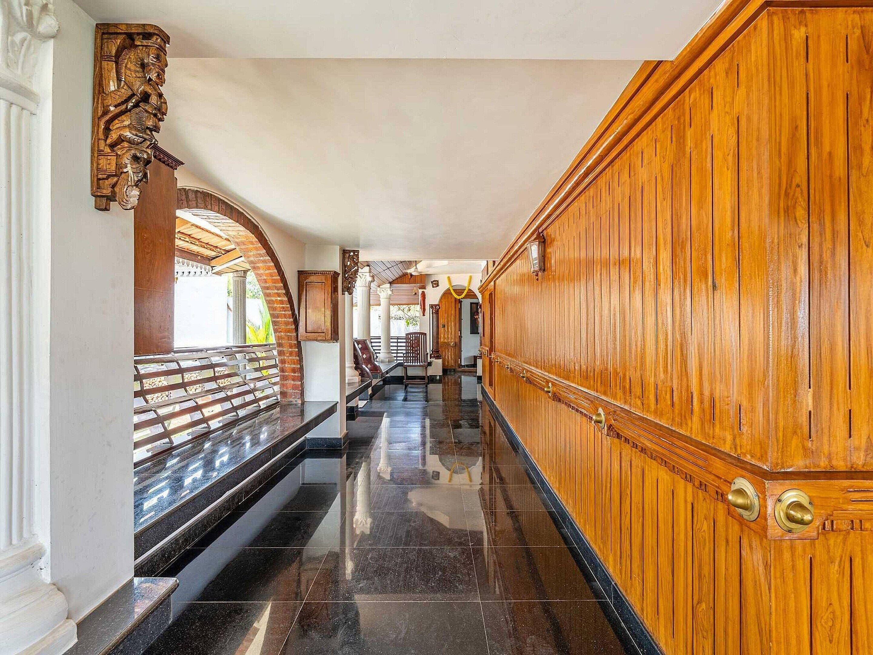 A long, polished hallway with wooden paneling and marble steps.