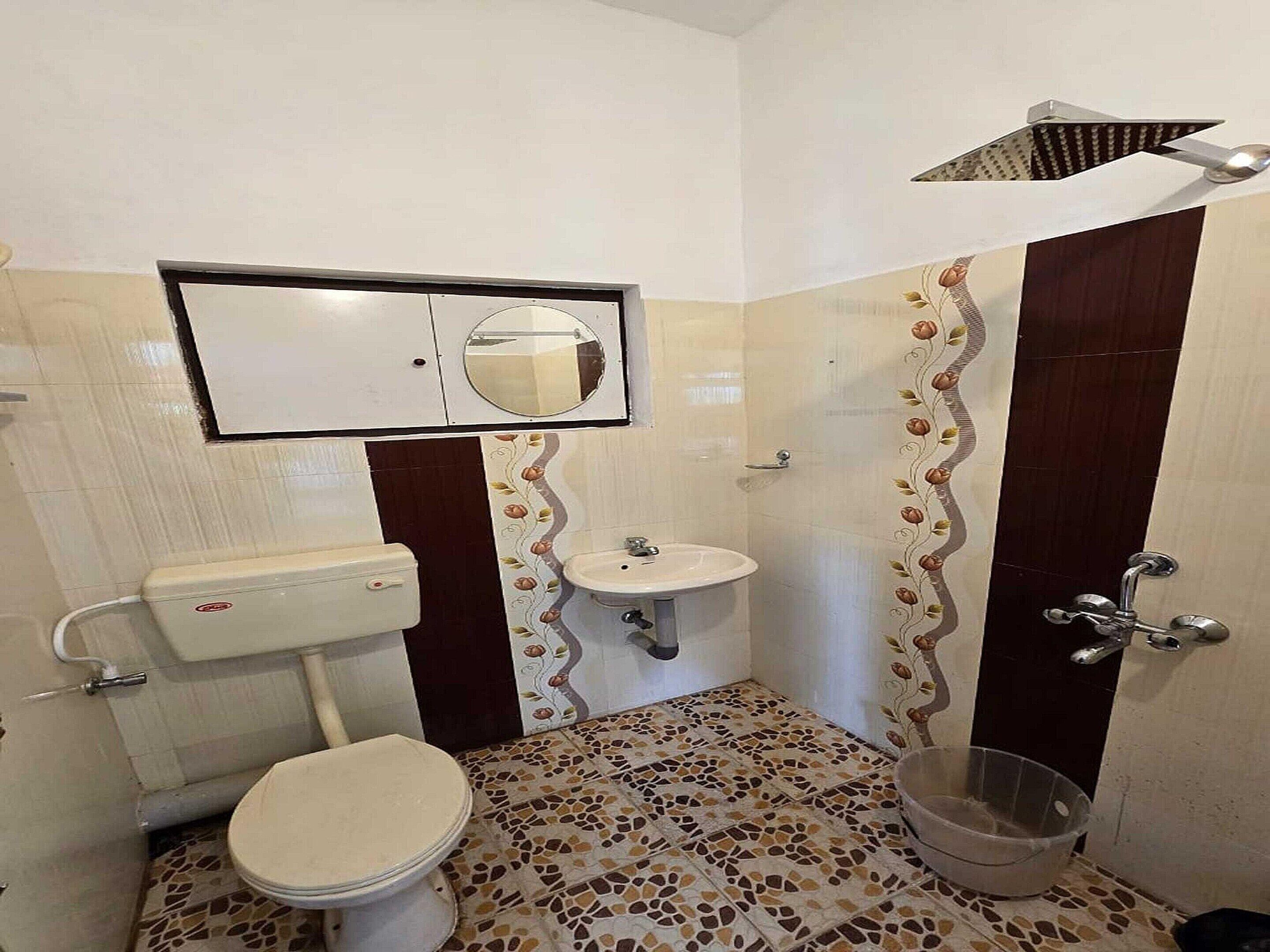 A bathroom with a toilet, sink, and shower.