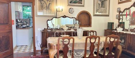 A dining room with a wooden table, chairs, and a patterned rug.