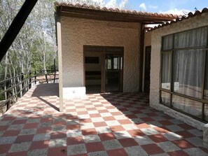 A covered outdoor area with a checkered floor, a door, and a window.
