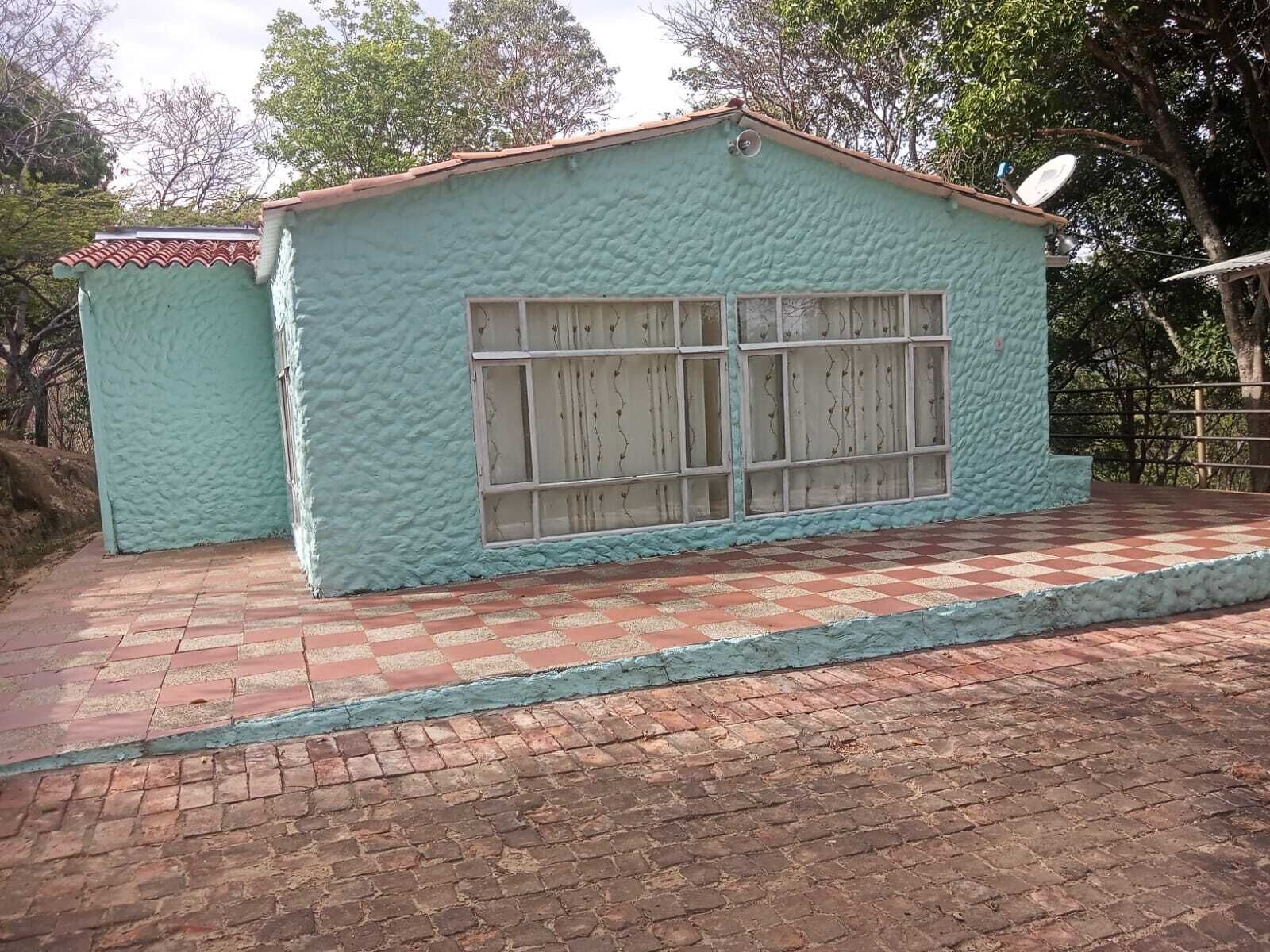Un bâtiment à l’extérieur texturé, une fenêtre à motifs géométriques et une antenne parabolique sur le toit.