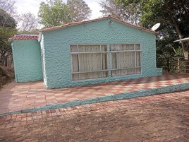 Un edificio con fachada texturizada, una ventana de diseño enrejado y una antena parabólica en el techo.