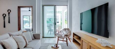 A modern living room with a sofa, coffee table, TV, and a chair.