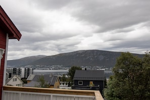 A residential area with houses, a mountain, and a body of water in the background. - Arctic Comfort 1, Tromsø (Tromsø)