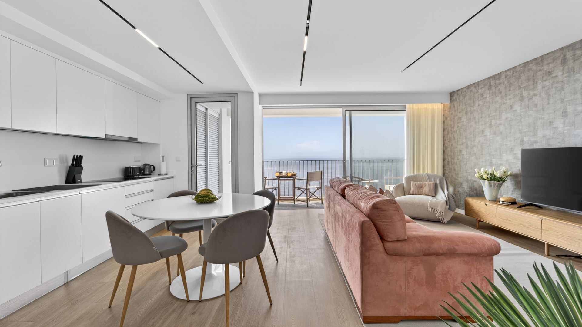 En moderne lejlighed med køkken, spiseområde, opholdsstue og balkon med udsigt.