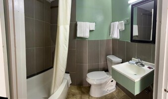 A bathroom with a bathtub, toilet, and sink.