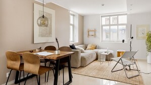 Una sala moderna con comedor, un sofá, una mesa de centro y una lámpara.