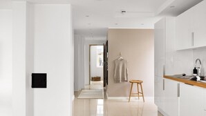 Una cocina moderna con armarios blancos, encimera de madera y pileta de acero inoxidable.