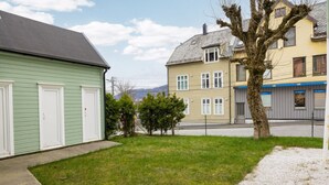 Un barrio residencial con casas, un patio cubierto de césped y un árbol.